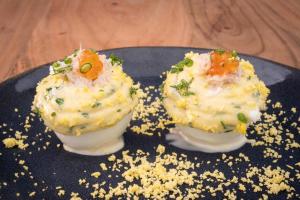 two deviled eggs on a plate on a table at Hôtel De La Vallée in Dinard