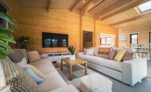 una sala de estar con sofás y TV en una habitación en Sundance Lodge, Fantastic New Cabin with Hot Tub - Sleeps 6 - Largest In Felmoor Park, en Morpeth