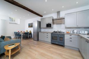uma cozinha com armários brancos e um fogão azul em Harbour Moorings em St. Ives