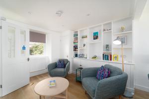a living room with two chairs and a table at Harbour Moorings in St Ives