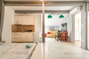 イゾラにあるHangar Apartmentsの白いキャビネットと緑の照明のあるキッチンとリビングルーム