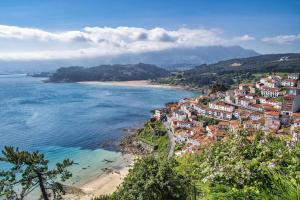Una vista de una playa con casas y el océano. en Casa Noval, zona rural VV-3120-AS, en Bimenes