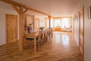 a dining room with a wooden table and chairs at Viesu māja Jānis in Madona