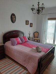 una camera da letto con un grande letto con cuscini rosa e viola di MARIA INÊS HOUSE a Nazaré
