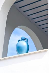 Villa Katerina في Punta: وجود مزهرية زرقاء على حافة النافذة
