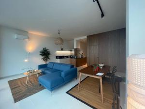 a living room with a blue couch and a table at 3-bedroom beach villa with a pool in Green Coast Palase in Palasë