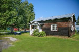 uma pequena casa de madeira com uma mesa num quintal em Trollforsen Camping & Cottages em Gargnäs