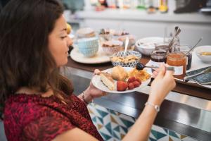 a woman is holding a plate of food at Hôtel De La Vallée in Dinard