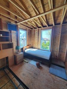 um pequeno quarto com uma cama e duas janelas em Room in Cabin - Camping Cabin With Sauna Access 2nd Fl- em Dover
