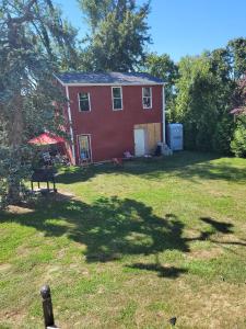 a red house in a yard with a dog in it at Room in Cabin - Camping Cabin With Sauna Access 2nd Fl- in Dover