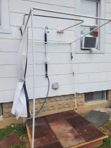 um chuveiro instalado fora de uma casa em Room in Cabin - Camping Cabin With Sauna Access 2nd Fl- em Dover