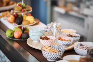 a table with bowls of food and plates of fruit at Hôtel De La Vallée in Dinard