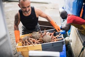 two men loading a box of lobsters into a truck at Hôtel De La Vallée in Dinard