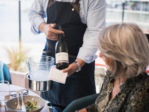a man pouring a bottle of wine for a woman at Hôtel De La Vallée in Dinard