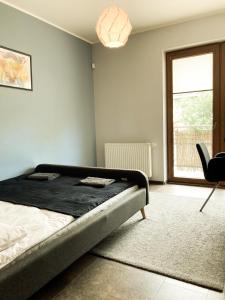 a bedroom with a bed and a window and a chair at Apartment Gdansk Close to Oldtown in Gdańsk
