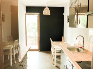 a kitchen with a sink and a table with chairs at Apartment Gdansk Close to Oldtown in Gdańsk