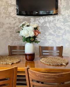 a vase of flowers sitting on a wooden table at White Home in Žabljak +27 photos