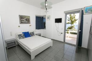 a white room with a bed and a window at Villa Ilios in Parga