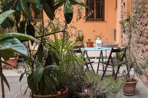 um pátio com uma mesa, cadeiras e plantas em La Corte em Arezzo