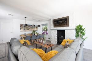 a living room with a gray couch and a fireplace at Kerenza Sands, Praa Sands in Praa Sands