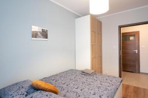 a bedroom with a bed with an orange pillow on it at Golden Apartments/Op25 in Katowice