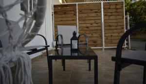 a porch with two chairs and a table and a fence at George & Dimitra's House in Kharokopión +19 photos