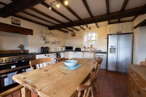 cocina con mesa de madera y nevera en Hulmes Vale House - Sleeps 14 - Peak district, en Buxton