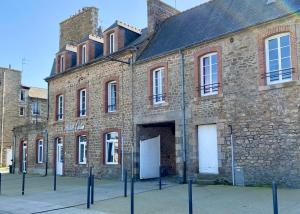 an old brick building with white doors and windows at Hôtel Océan Dinan in Dinan