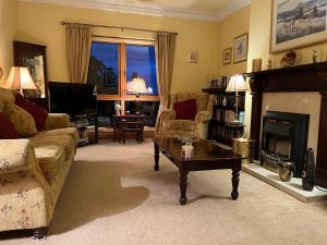 a living room with a couch and a fireplace at Cherryvale 3 bedroom 6 person holiday home in Hilltown