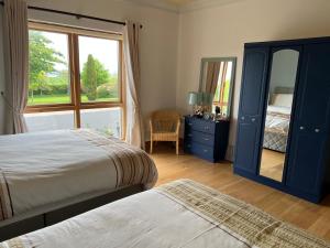 a bedroom with two beds and a mirror and a window at Cherryvale 3 bedroom 6 person holiday home in Hilltown