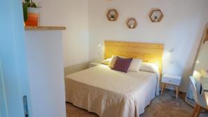 1 dormitorio con 1 cama con cabecero de madera en Castellabate Apartments Camere, en Castellabate