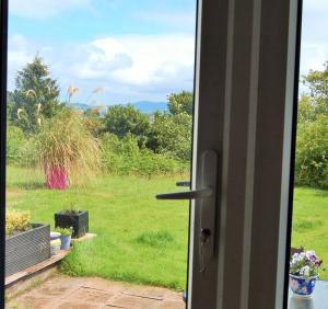una puerta abierta con vistas a un campo en The Annex, Kilbride Farmhouse, en Dunoon