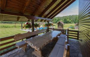 einen großen Holztisch und Bänke auf einer Terrasse in der Unterkunft 3 Bedroom Gorgeous Home In Cacinci in Čačinci
