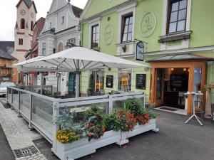 um suporte de flores em frente a um edifício com um guarda-chuva em Frühstückspension Reinhard Todt em Zwettl Stadt