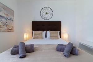 sypialnia z dużym łóżkiem z zegarem na ścianie w obiekcie CANARIAN HOLIDAY HOME - Luxury Condo near Yumbo w mieście San Bartolomé +26 zdjęć