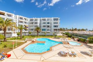 duży budynek apartamentowy z dużym basenem w obiekcie CANARIAN HOLIDAY HOME - Luxury Condo near Yumbo w mieście San Bartolomé
