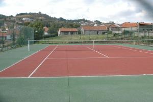 a tennis court with a tennis net on it at Casa Da Eira Longa in Vilar