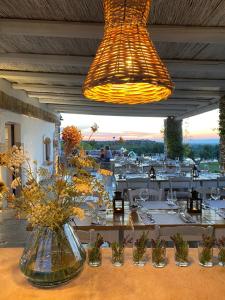 un restaurante con mesas blancas y jarrones con flores en Lama Di Luna Biomasseria en Montegrosso