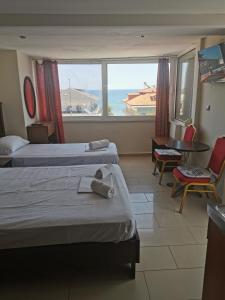 パラリア・カテリニスにあるValentina Hotelのベッド2台が備わる海の景色を望むホテルルームです。