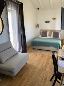 a bedroom with a bed and a chair and a table at The Pines - Experiment Favelas in Vama Veche