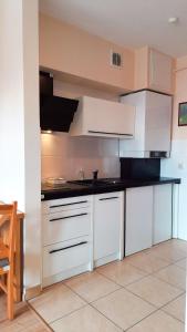 a kitchen with white cabinets and black counter tops at APARTAMENTY T.R.11 Apartament nr 3 in Olsztyn