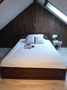 a bedroom with a large bed with a wooden wall at apartamentyDvorskie in Nowy Sącz