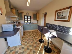 a kitchen with a counter and two chairs in it at Swallows Nest in Abergavenny