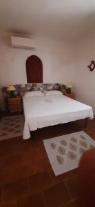 una camera da letto con un letto con copriletto bianco di Il Villaggio Del Mago a Lampedusa