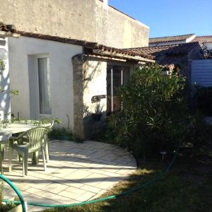 a house with a patio with a green hose at Maison charmante à Sainte-Marie-de-Ré avec terrasse in Sainte-Marie-de-Ré