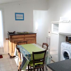 a kitchen with a table and a washing machine at Maison charmante à Sainte-Marie-de-Ré avec terrasse in Sainte-Marie-de-Ré