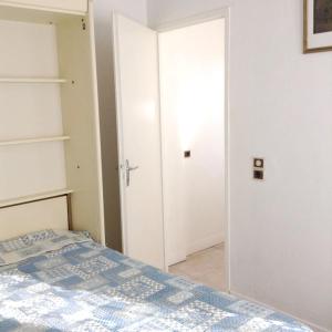 a bedroom with a bed and an open door at Maison charmante à Sainte-Marie-de-Ré avec terrasse in Sainte-Marie-de-Ré +3 photos