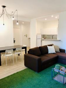 uma sala de estar com um sofá castanho e uma mesa em appartmentslapiazzetta - n.4 em Sesto Calende