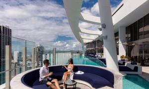 um homem e uma mulher sentados num sofá no telhado de um edifício em Skyline at Casino 2bedrooms em Gold Coast