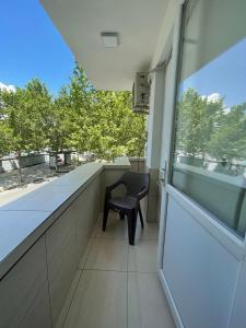 a chair sitting in a room with a window at Lovely one-bedroom apartment with private entrance in Tirana